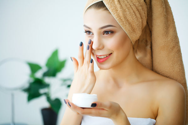 woman applying skin cream on face