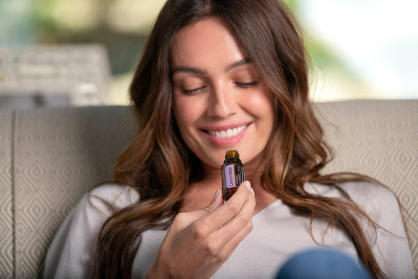 woman using bottle of lavender essential oil