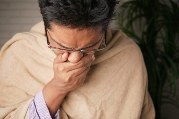 man covering mouth and nose for infection precaution