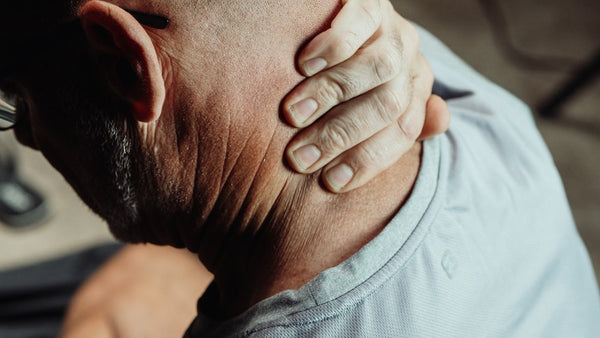 man rubbing neck to check spine pain
