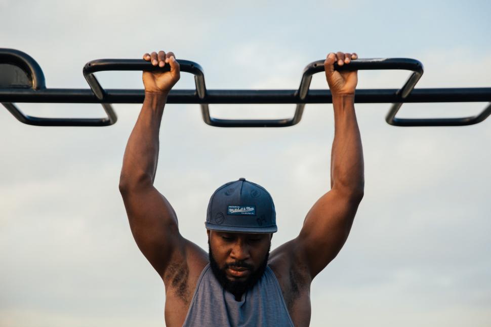 a man doing hanging exercise to get in shape for summer