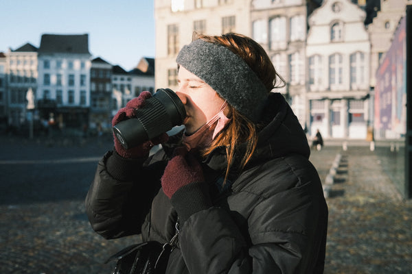 woman dressed warm drinking a hot beverage