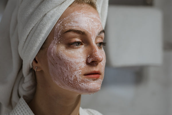woman cleaning face to avoid crepey skin