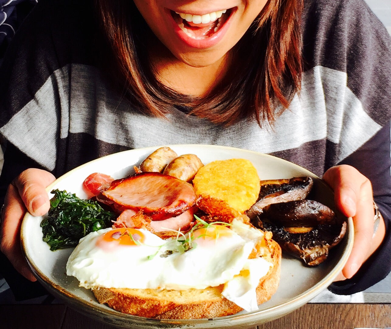 close-up of a smiling girl holding a plate mixed of friendly diet foods