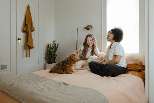 women sitting on bed with pets