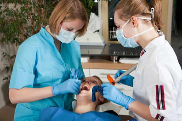 dentists studying patient for gum disease