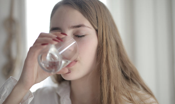 woman drinking water to help fight bad breath