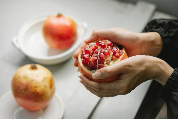 woman preparing pomegranates health benefits