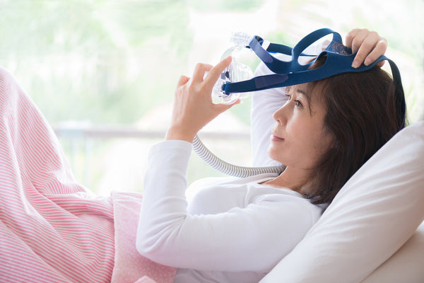 woman wearing CPAP mask for sleep apnea
