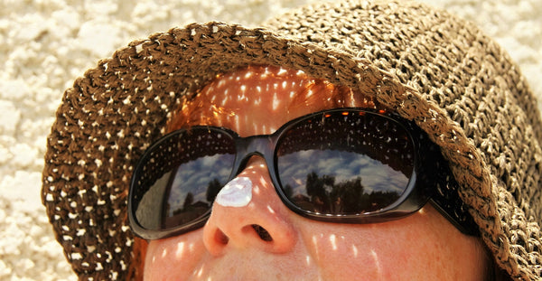 woman wearing hat and sunglasses to protect against melanoma