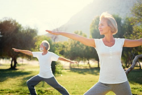 old man and woman doing yoga to beat the effects of aging